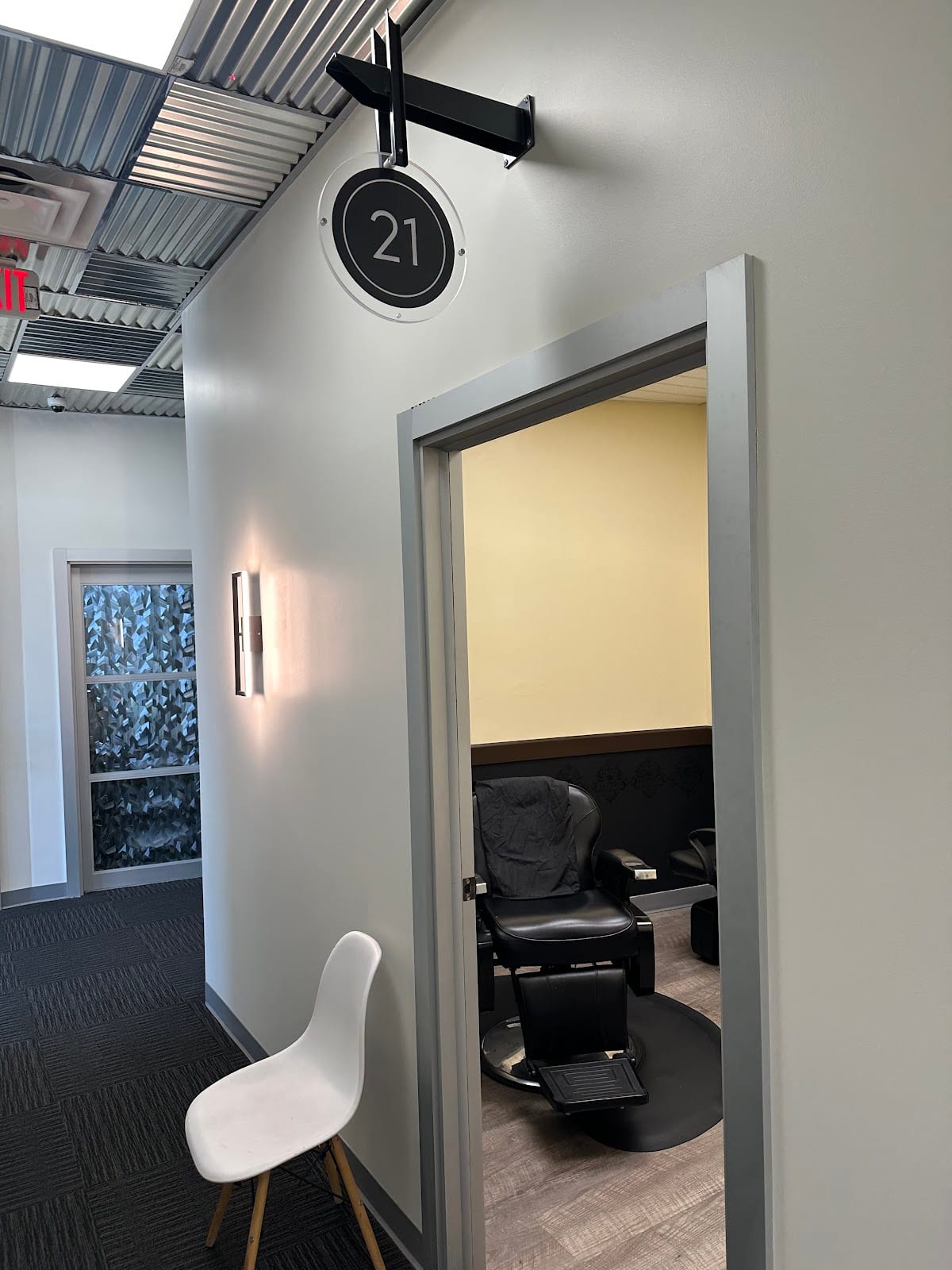 The round black 21 sign over the door of her suite, with the barber chair inside